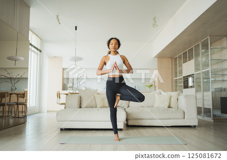 Yoga fitness workout training. Healthy African girl practicing yoga at home. Woman training Pilates doing sports exercise on yoga mat indoor. Girl have training workout for weight loss. Sport fitness Yoga fitness workout training. Healthy African girl practicing yoga at home. Woman training Pilates doing sports exercise on yoga mat indoor. Girl have training workout for weight loss. Sport fitness 125081672