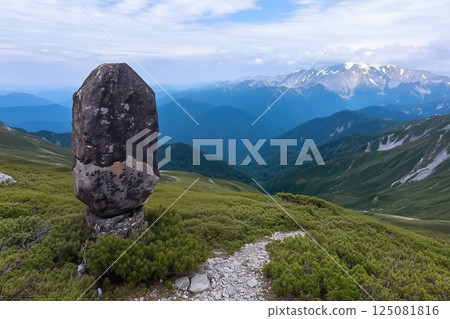 Mountain landscape with a large stone empty road sign in the foreground and a mountain range in the background 125081816
