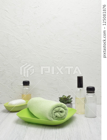 A folded green towel with soap on a light background, ideal for design mockups with space for text and promotional content. 125081876