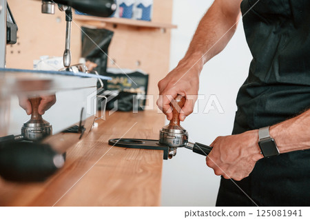 Preparing coffee by special tool. Barista in the cafe. Close up view 125081941