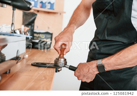 Preparing coffee by special tool. Barista in the cafe. Close up view 125081942