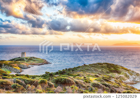 Marvelous sunset view of Piscinni bay with turquoise sea and famous coastal tower of Piscinni. 125082029