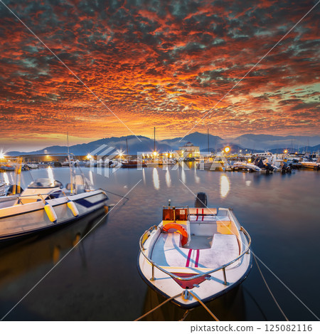 Exciting sunset view on boats in beautiful marina of Villasimius. 125082116