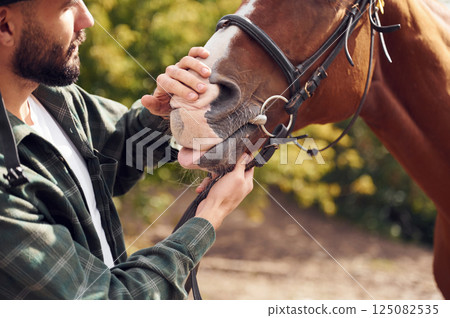 Young man with a horse is outdoors 125082535
