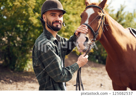 Young man with a horse is outdoors Young man with a horse is outdoors 125082537