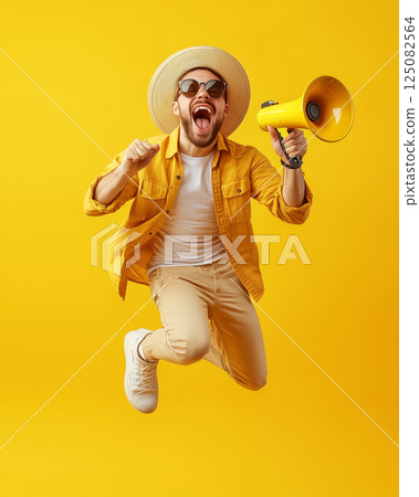 Young businessman joyfully jumps with a megaphone in a bright yellow scene 125082564