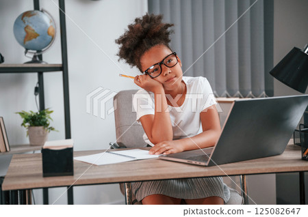 Feeling bored. Cute female african american student child is sitting by the laptop 125082647