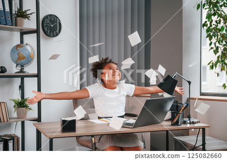 Throwing stickers up in the air. Celebrating success. Cute female african american student child is sitting by the laptop 125082660