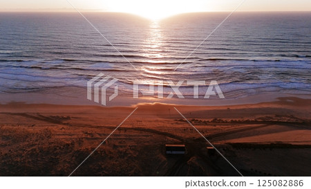 Aerial Sunset View Over Ocean Waves and Sandy Beach Aerial Sunset View Over Ocean Waves and Sandy Beach 125082886