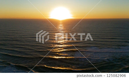Golden Sunset Reflections Across Ocean Waves from Drone View Golden Sunset Reflections Across Ocean Waves from Drone View 125082906
