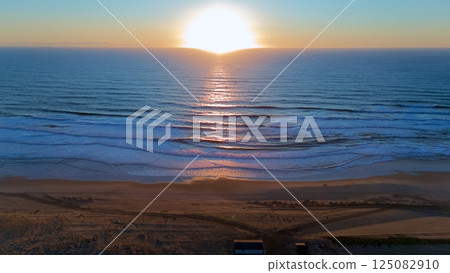 Drone Captures Serene Ocean Sunset Over Waves and Beach Drone Captures Serene Ocean Sunset Over Waves and Beach 125082910
