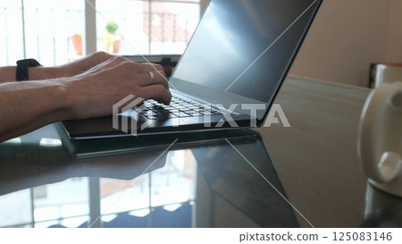 Modern Workspace with Laptop and Hands Typing on Keyboard 125083146