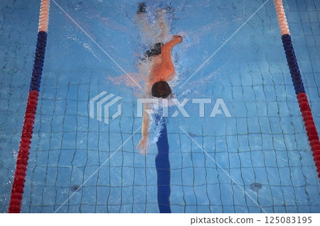 Man swimming in a pool freestyle 125083195