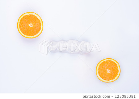 Enlarged anatomical plaster model of four lateral teeth with two halves of an orange on the sides. Enlarged anatomical plaster model of four lateral teeth with two halves of an orange on the sides. 125083381