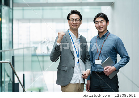 Businessmen working in an office. Filming cooperation: SKY Perfect Tokyo Media Center Businessmen working in an office. Filming cooperation: SKY Perfect Tokyo Media Center 125083691