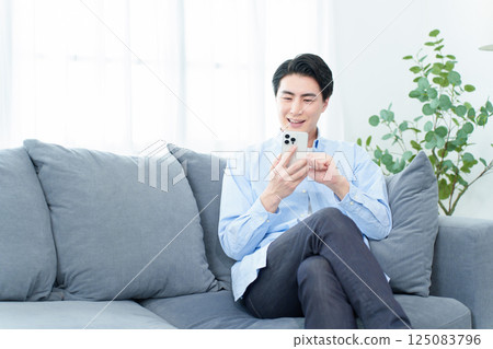 A man who uses smartphones in the living room 125083796