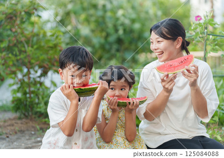 Parents and children eating watermelon during summer vacation Parents and children eating watermelon during summer vacation 125084088