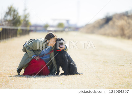 A woman walking a dog A woman walking a dog 125084297