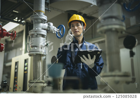 樓宇維護人員圖片：一名工人用平板電腦檢查供水設備 125085028