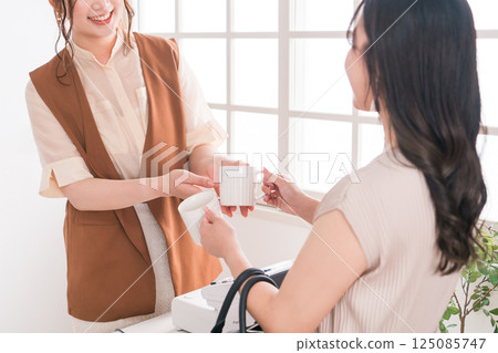 一位女士在雜貨店（收銀台、收銀台、POS 收銀機）購買餐具、馬克杯和杯子 125085747