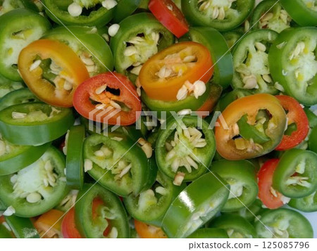 A layer of sliced Mexican green chili peppers (Serrano chiles) 125085796