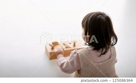 Rear view of a small child playing with toys 125086364