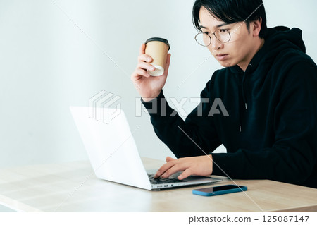 年輕人邊喝咖啡邊看電腦 125087147