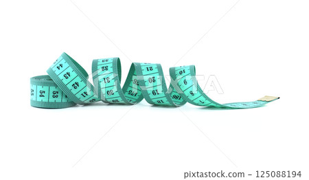 A coiled turquoise measuring tape lies on a white surface, ready for precise tailoring. 125088194