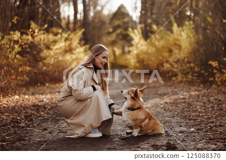 Woman with Corgi in Autumn Park Woman with Corgi in Autumn Park 125088370