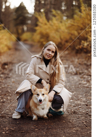 Woman with Corgi in Autumn Park 125088380