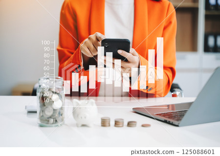 businesswoman holding coins putting in glass with using smartphone and calculator to calculate concept saving money businesswoman holding coins putting in glass with using smartphone and calculator to calculate concept saving money 125088601