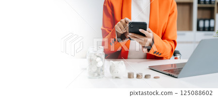 businesswoman holding coins putting in glass with using smartphone and calculator to calculate concept saving money businesswoman holding coins putting in glass with using smartphone and calculator to calculate concept saving money 125088602