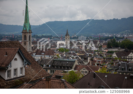Stunning panoramic view of Zurich showcasing historic architecture and breathtaking mountains in the backdrop 125088966