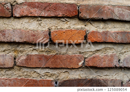 Discovering the rich textures of time-worn bricks in a rustic wall set under soft natural light Discovering the rich textures of time-worn bricks in a rustic wall set under soft natural light 125089054