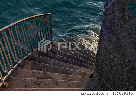 Stairway leading to serene waters near picturesque buildings by Bodensee 125089119