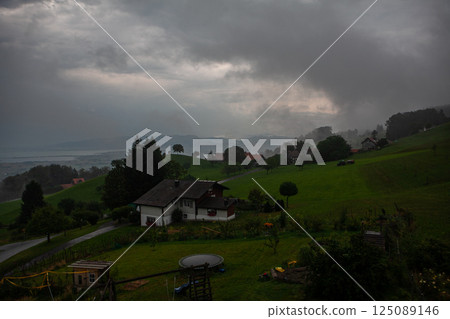 Captivating storm clouds hover over lush green hills near Lake Bodensee in Switzerland Captivating storm clouds hover over lush green hills near Lake Bodensee in Switzerland 125089146