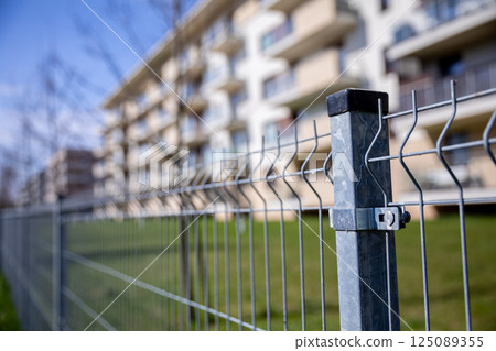 Contemporary Modern Apartment with a View from Behind a Wire Fence and Beautiful Green Lawn Contemporary Modern Apartment with a View from Behind a Wire Fence and Beautiful Green Lawn 125089355