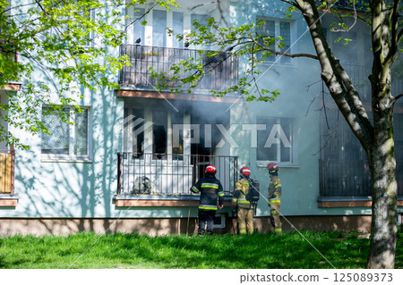 Firefighters are bravely battling a major residential blaze in an urban area, showing skill Firefighters are bravely battling a major residential blaze in an urban area, showing skill 125089373