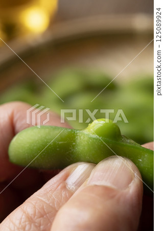 用手端上煮好的毛豆 用手端上煮好的毛豆 125089924