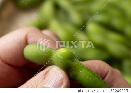 用手端上煮好的毛豆 用手端上煮好的毛豆 125089925