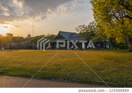 Osaka Guest House illuminated by the setting sun during cherry blossom season 125089989