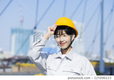 Woman in work clothes at a construction site 125090223
