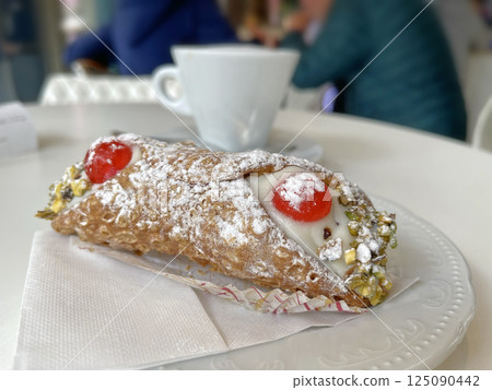 Cannoli on plate with cappuccino. Food and drink. Traditional Italian dessert. 125090442