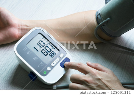 Man checks blood pressure monitor and heart rate monitor with digital pressure gauge. Health care and Medical concept. 125091311