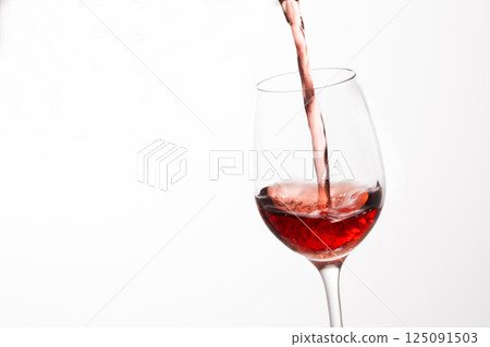 Pour the red wine into the glass 125091503
