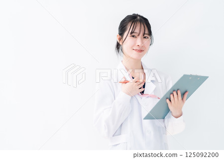 A female doctor in a white coat holding a file to ask a question, white background 125092200