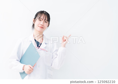A female doctor pointing at a clinic, white background A female doctor pointing at a clinic, white background 125092210