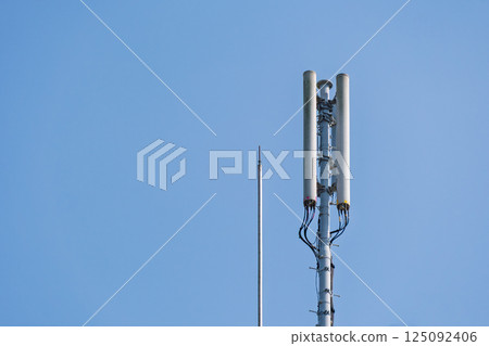 Mobile phone base station antenna and lightning rod against the blue sky 125092406