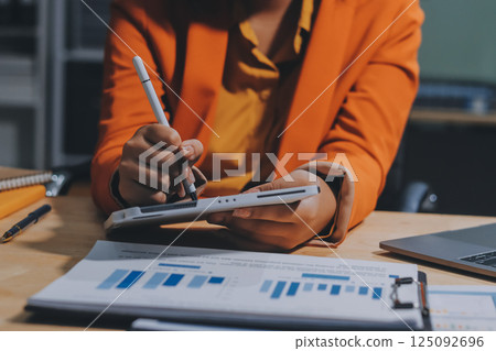 Businesswoman or accountant working Financial investment on calculator, calculate, analyze business and marketing growth on financial document data graph, Accounting, Economic, commercial concept. 125092696