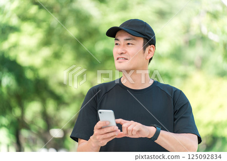 Health management with smartphone during exercise, middle-aged Asian man checking his health Health management with smartphone during exercise, middle-aged Asian man checking his health 125092834